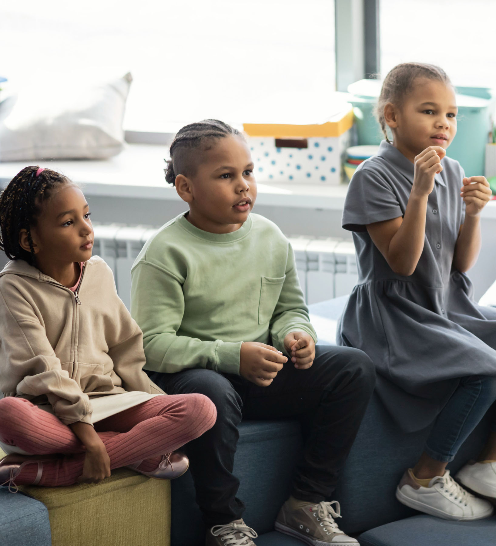 Self determined African American boy dressed in sports clothes planking at gym, feeling tired. Indoor image of black male kid doing elbow plank on floor at gym. Endurance and strength concept