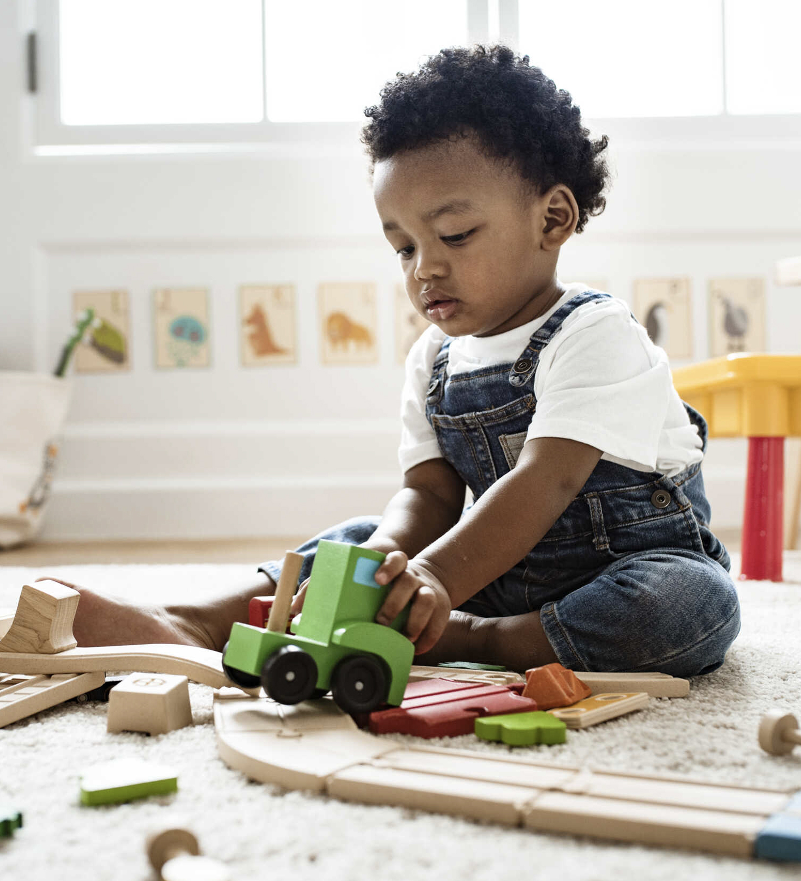 Cute little boy playing with a railroad train toy