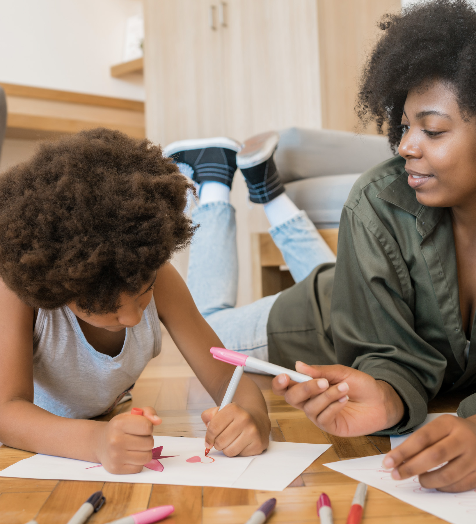 Self determined African American boy dressed in sports clothes planking at gym, feeling tired. Indoor image of black male kid doing elbow plank on floor at gym. Endurance and strength concept